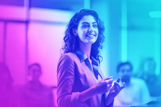 Femme d'affaires souriante présentant à l'oral des informations à un groupe de collègues